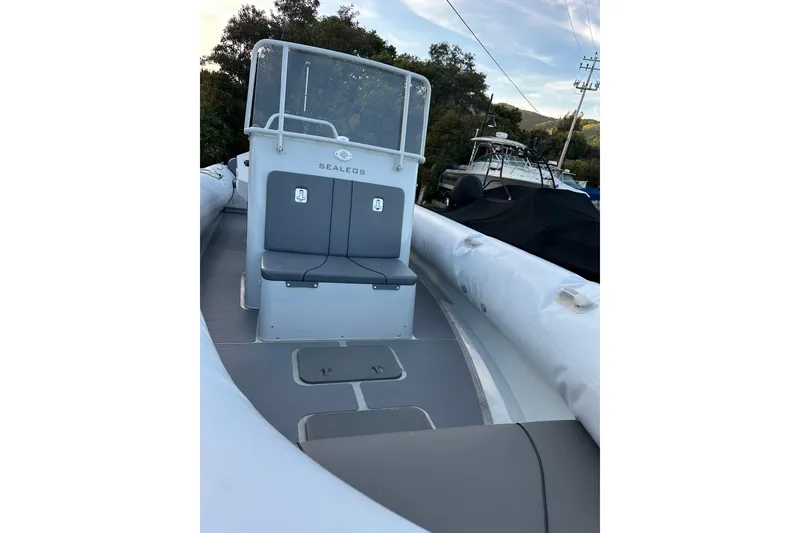 Slide: The Image of 2020 Sealegs 9m Amphibious RIB with seating, docked outdoors. - 14