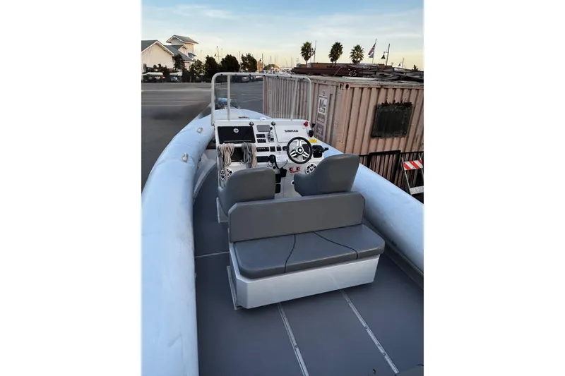 Slide: The Image of 2020 Sealegs 9m Amphibious RIB with modern cockpit and seating, docked near buildings. - 6