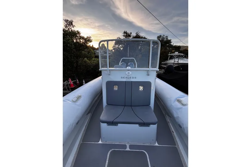 Slide: The Image of 2020 Sealegs 9m Amphibious RIB with seating, set against a scenic sunset backdrop. - 7