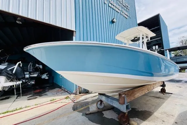 The Image of 2026 Boston Whaler 250 Dauntless boat in blue, displayed outside a blue warehouse. - 0
