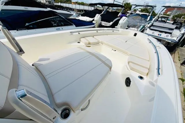 Slide: The Image of 2026 Boston Whaler 250 Dauntless boat with spacious seating and sleek design at a marina. - 11