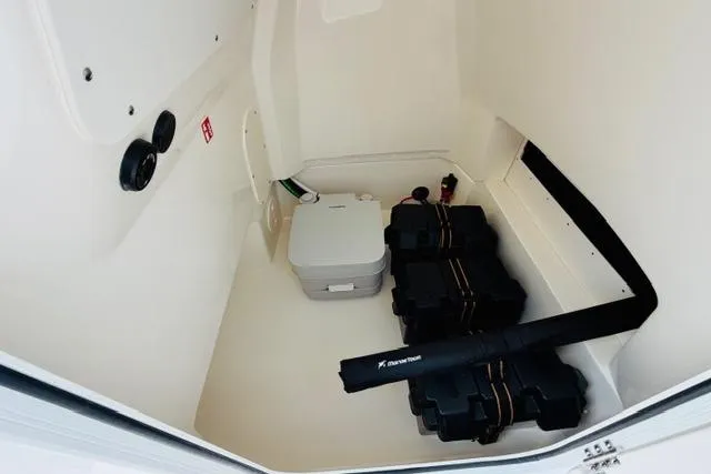 Slide: The Image of 2026 Boston Whaler 250 Dauntless interior storage compartment with equipment and portable toilet. - 12