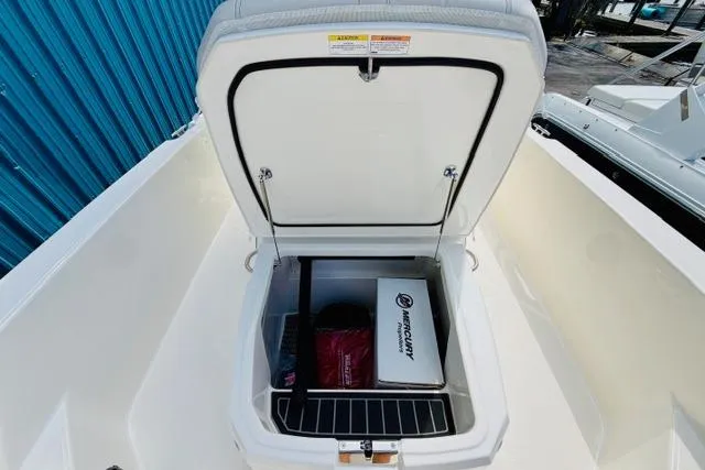 Slide: The Image of 2026 Boston Whaler 250 Dauntless storage compartment with Mercury equipment inside. - 13