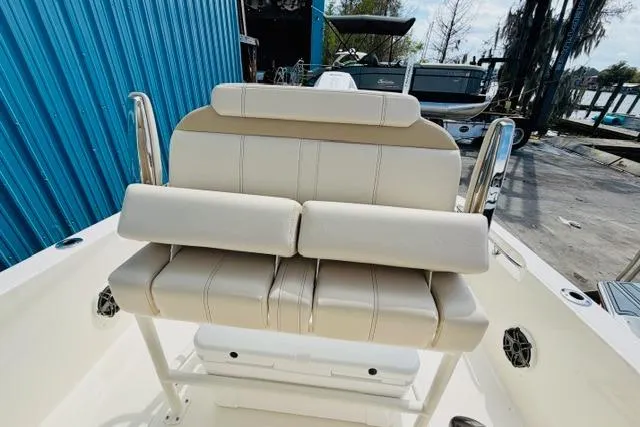 Slide: The Image of 2026 Boston Whaler 250 Dauntless boat with beige seating, docked near blue building. - 14