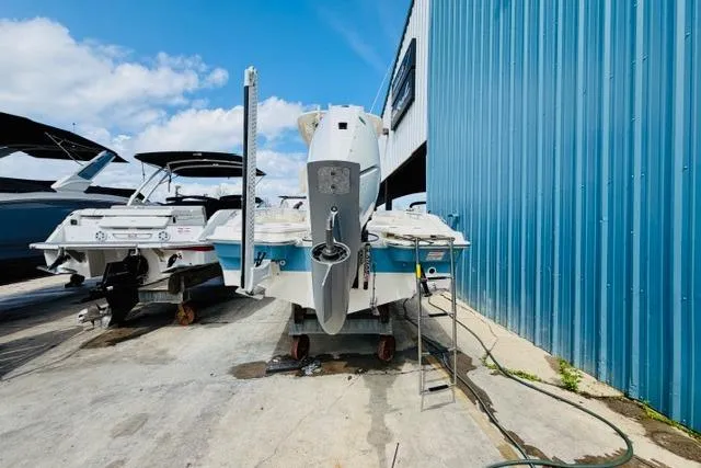 Slide: The Image of 2026 Boston Whaler 250 Dauntless boat docked near blue building under clear sky. - 4