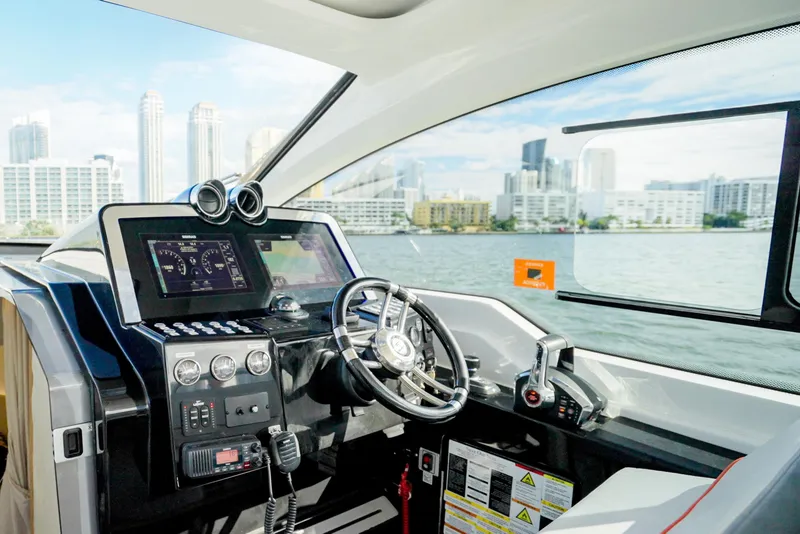 Slide: The Image of Interior of 2026 Granfort 370 GTX yacht with modern dashboard and city skyline view. - 11