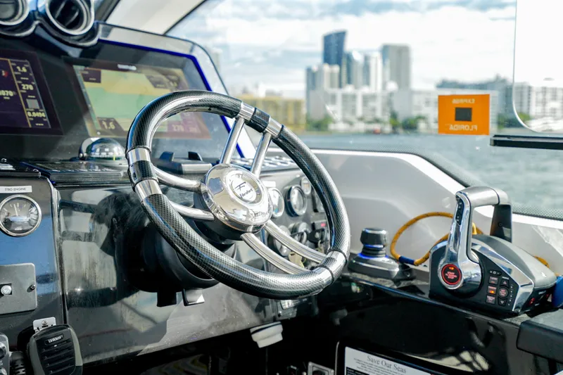 Slide: The Image of Steering wheel and controls of 2026 Granfort 370 GTX boat, with cityscape in background. - 13