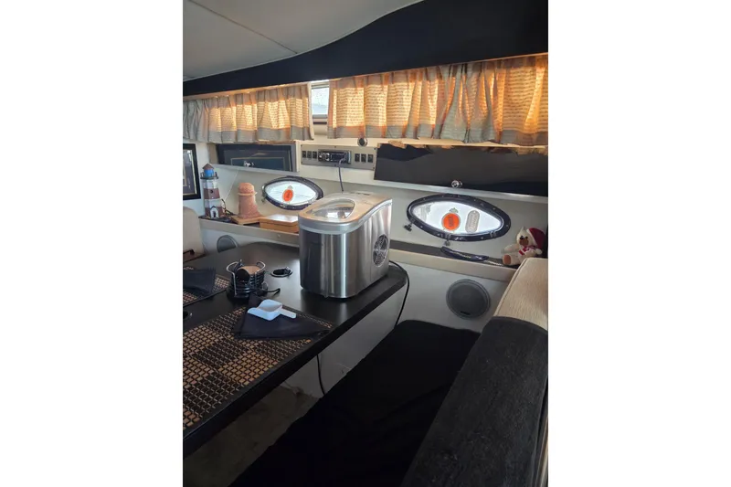 Slide: The Image of Interior of 1988 Wellcraft 3200 St. Tropez boat with dining area and porthole windows. - 13