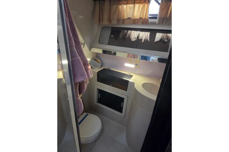 Slide: The Image of 1988 Wellcraft 3200 St. Tropez bathroom with sink, mirror, and storage cabinets. - 16