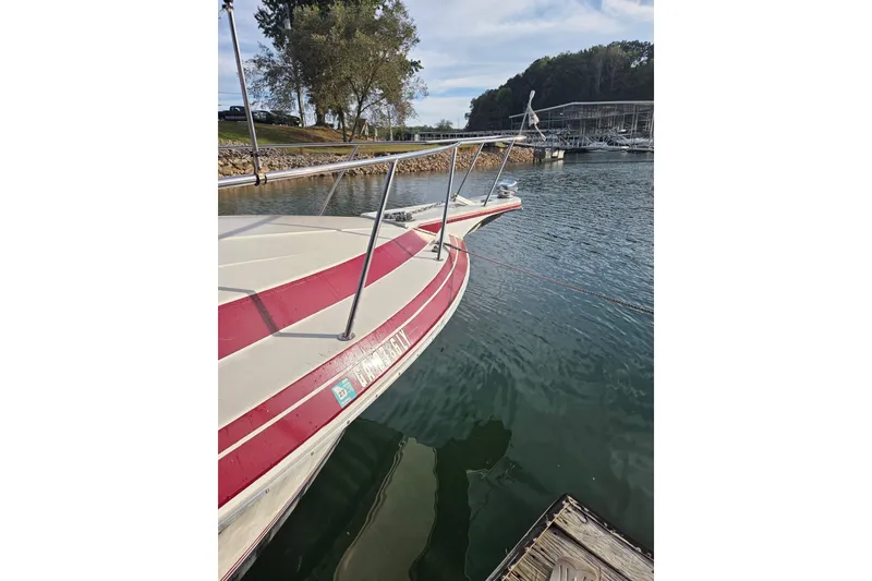 Slide: The Image of 1988 Wellcraft 3200 St. Tropez boat docked at a marina, calm water, clear sky. - 3