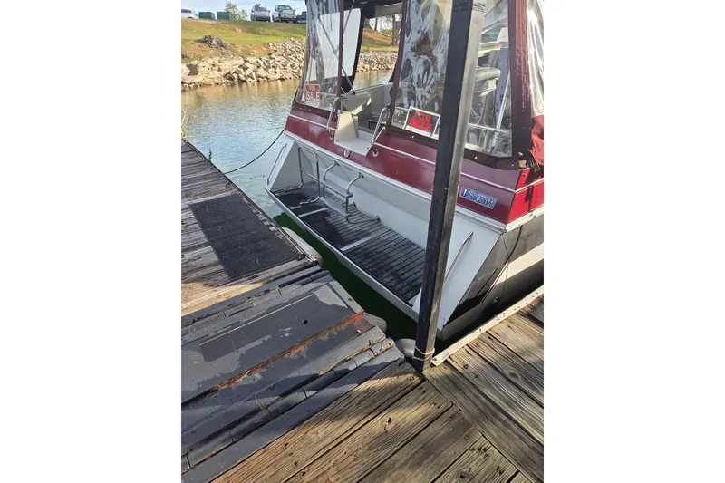 Slide: The Image of 1988 Wellcraft 3200 St. Tropez boat docked, rear view with "For Sale" sign. - 5