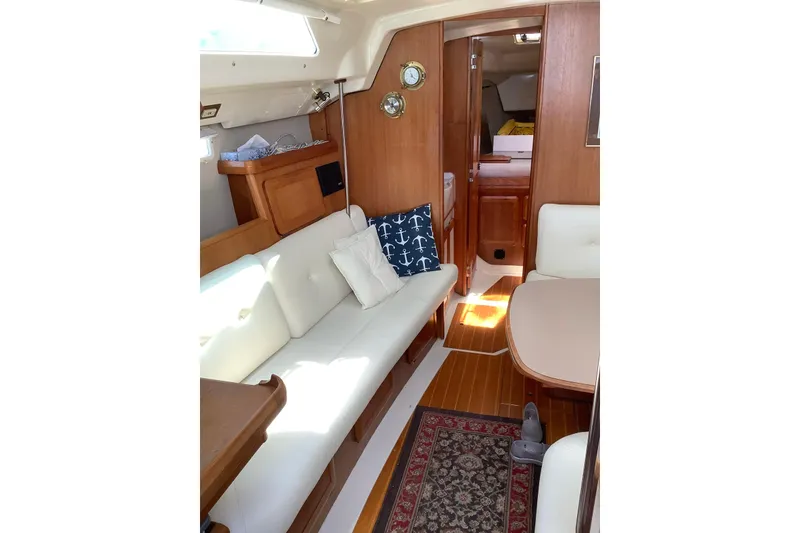 Slide: The Image of Cozy interior of a 1992 Hunter 33.5 sailboat with wood accents and cushioned seating. - 11