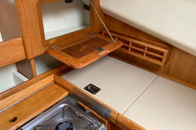 Slide: The Image of 1992 Hunter 33.5 yacht interior kitchen with wooden cabinetry and stove. - 15
