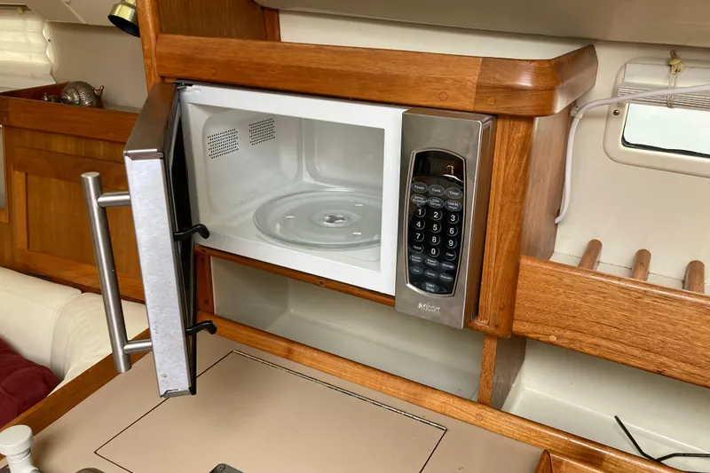 Slide: The Image of Microwave in 1992 Hunter 33.5 yacht kitchen with wooden cabinetry. - 18