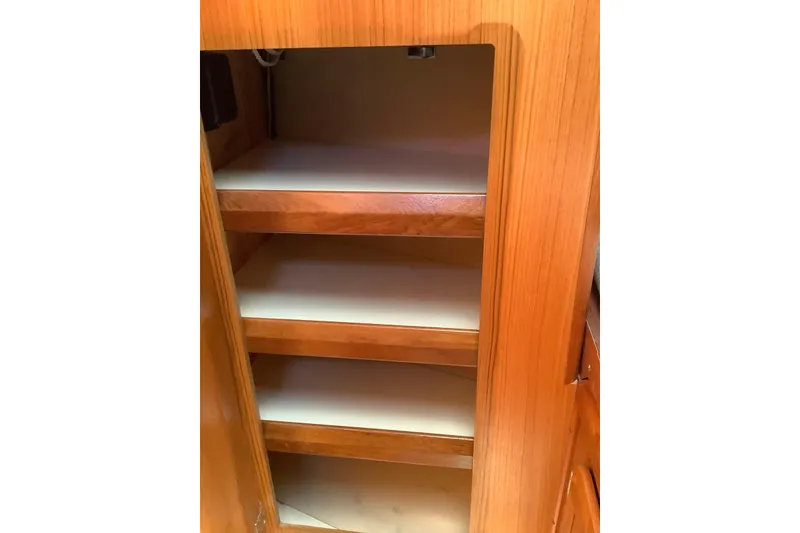 Slide: The Image of Wooden cabinet with shelves inside a 1992 Hunter 33.5 model boat. - 21