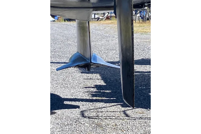 Slide: The Image of 1992 Hunter 33.5 sailboat keel and rudder on gravel surface. - 25