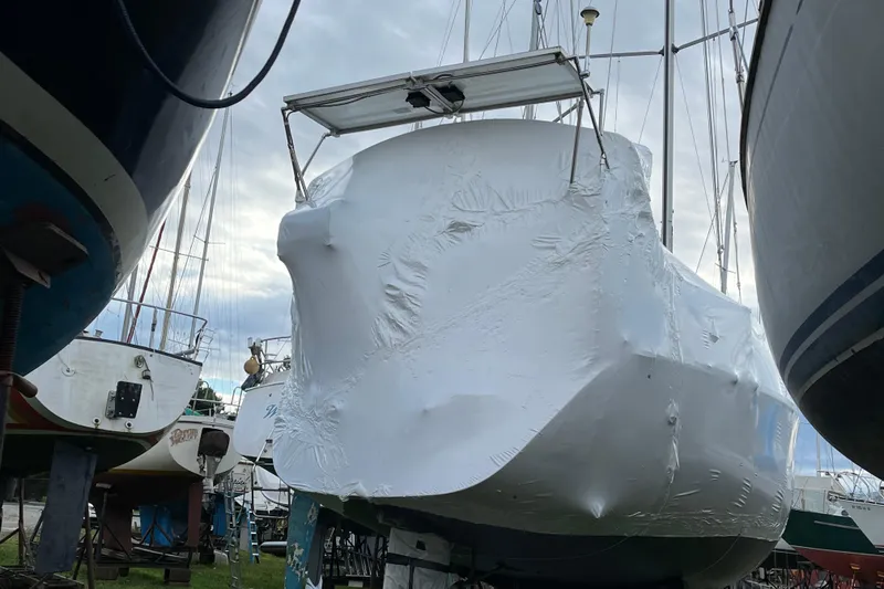 Slide: The Image of 1992 Hunter 33.5 sailboat covered in protective wrap, stored on land. - 30