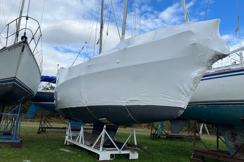 Slide: The Image of 1992 Hunter 33.5 sailboat wrapped in protective covering, stored on land. - 31