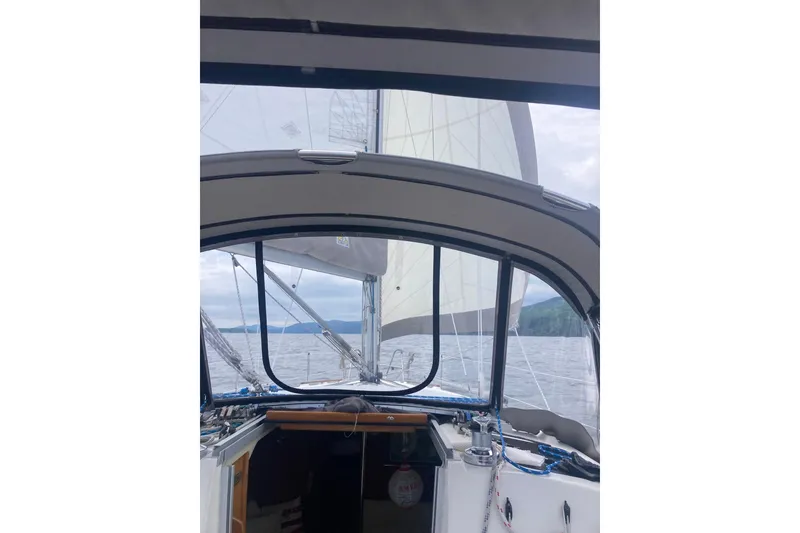 Slide: The Image of 1992 Hunter 33.5 sailboat cockpit view with sails on open water. - 5