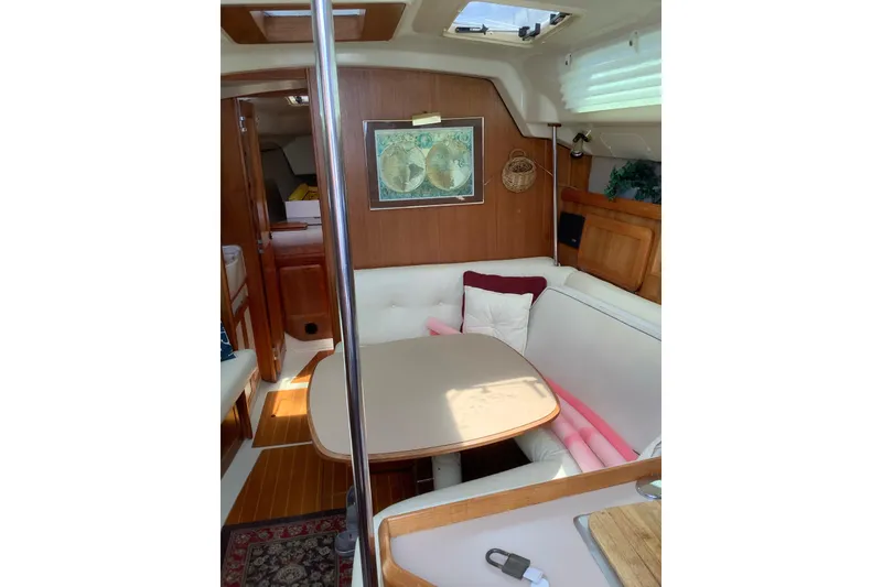 Slide: The Image of Interior of 1992 Hunter 33.5 sailboat with cozy dining area and wooden accents. - 9