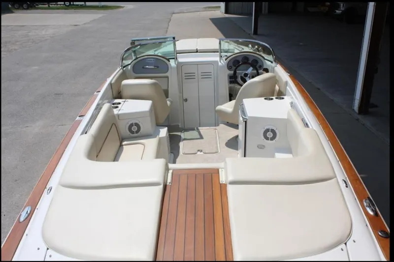 Slide: The Image of 2007 Chris-Craft Corsair 25 boat interior with beige seating and wooden deck. - 13