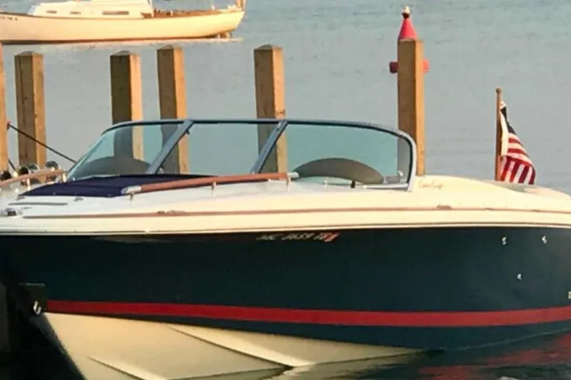 Slide: The Image of 2007 Chris-Craft Corsair 25 boat docked, featuring sleek design and American flag. - 5