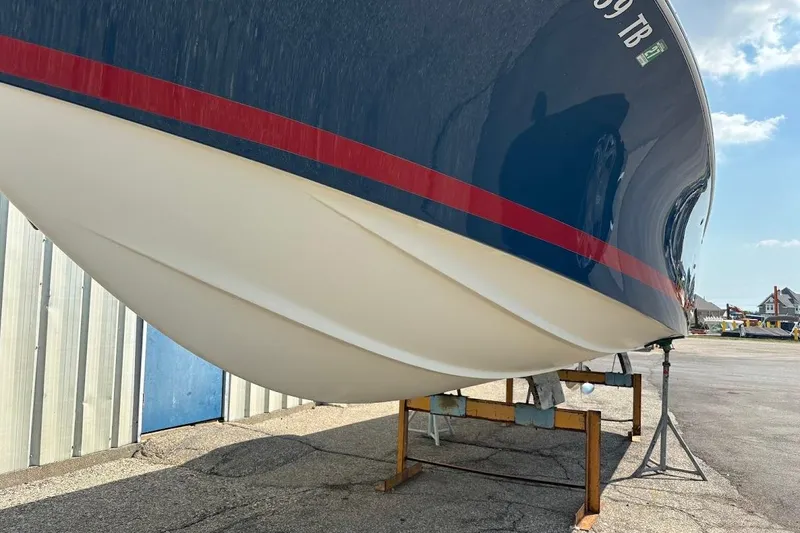Slide: The Image of 2007 Chris-Craft Corsair 25 boat hull on stand, blue with red stripe. - 8