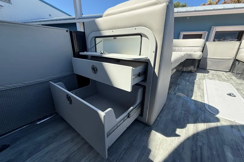 Slide: The Image of 2021 Crest Caribbean Platinum 250 SLC interior with open storage compartments and seating. - 16