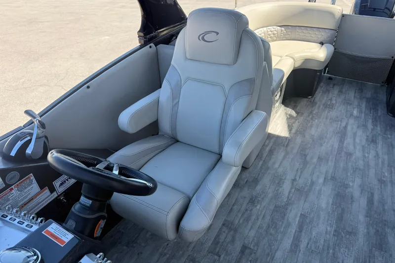 Slide: The Image of 2021 Crest Caribbean Platinum 250 SLC boat interior with captain's chair and steering wheel. - 21