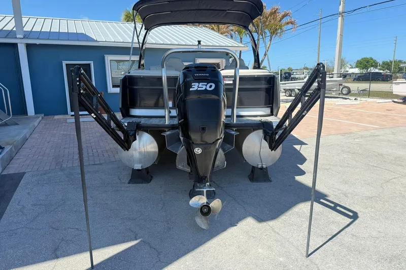 Slide: The Image of 2021 Crest Caribbean Platinum 250 SLC pontoon boat with powerful 350 engine, docked outdoors. - 3