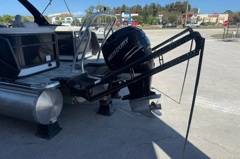 Slide: The Image of 2021 Crest Caribbean Platinum 250 SLC pontoon boat with Mercury outboard motor in a parking lot. - 4