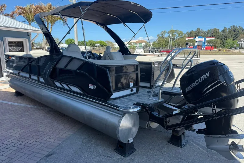 Slide: The Image of 2021 Crest Caribbean Platinum 250 SLC pontoon boat with Mercury engine, docked outdoors. - 5