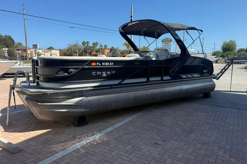 Slide: The Image of 2021 Crest Caribbean Platinum 250 SLC pontoon boat on display in a parking lot. - 6