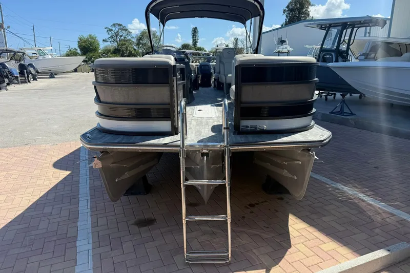 Slide: The Image of 2021 Crest Caribbean Platinum 250 SLC pontoon boat with ladder, parked outdoors. - 7