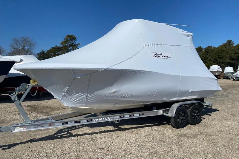 The Image of 2026 Pioneer 222 Islander boat covered on trailer, parked outdoors. - 0