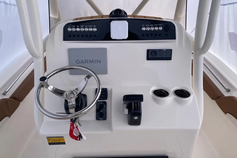 Slide: The Image of 2026 Pioneer 222 Islander boat console with Garmin navigation, steering wheel, and controls. - 2