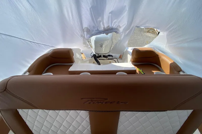 Slide: The Image of 2026 Pioneer 222 Islander boat interior with brown leather seating and covered engine. - 3
