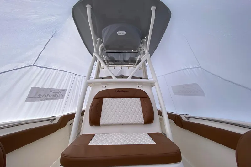 Slide: The Image of 2026 Pioneer 222 Islander boat interior with brown and white seating under a canopy. - 4