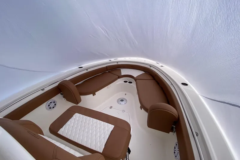 Slide: The Image of 2026 Pioneer 222 Islander boat interior with brown seating and white accents. - 5