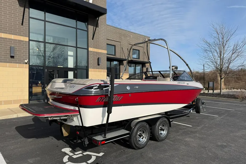 Slide: The Image of 2008 Malibu Sunscape 23 LSV boat on trailer, parked outside modern building. - 3