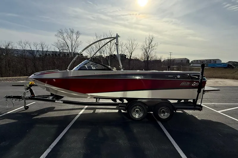 Slide: The Image of 2008 Malibu Sunscape 23 LSV boat on trailer in parking lot, under sunny sky. - 6