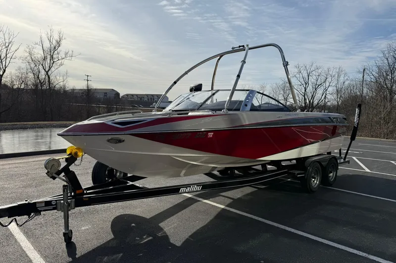 Slide: The Image of 2008 Malibu Sunscape 23 LSV boat on trailer in parking lot, under clear sky. - 7