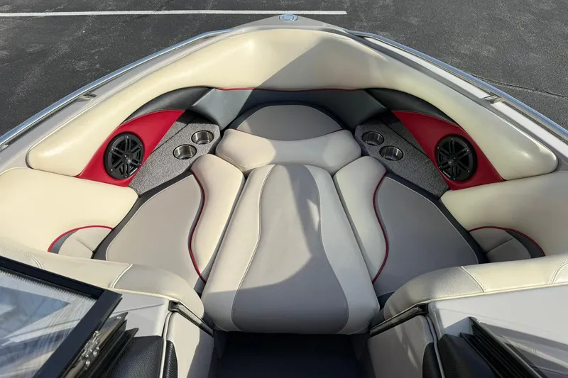 Slide: The Image of 2008 Malibu Sunscape 23 LSV boat interior with beige and red seating, speakers, and cup holders. - 9