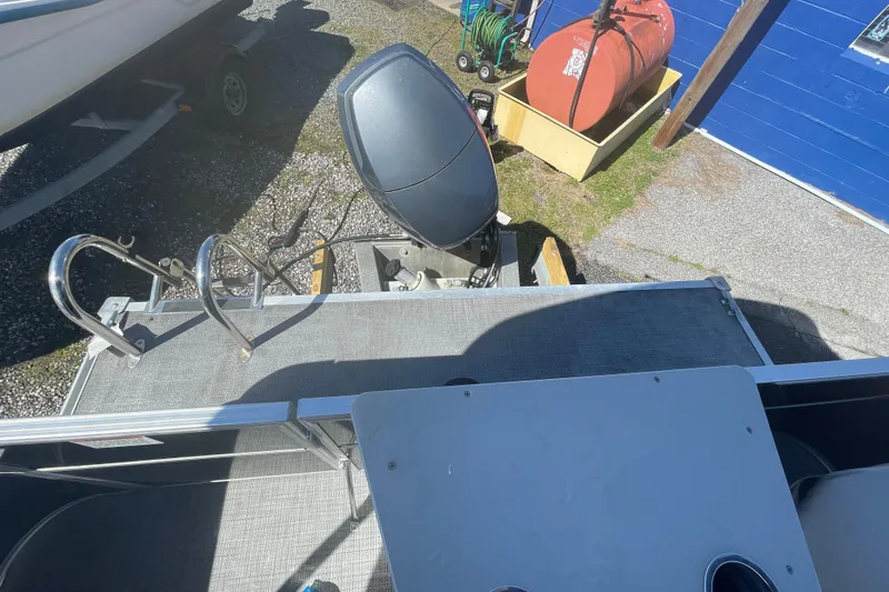 Slide: The Image of 2016 Starcraft EX 20 CF boat with outboard motor and ladder, parked on gravel. - 10