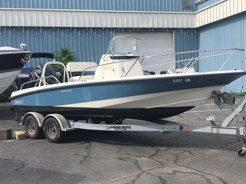 The Image of 2012 Boston Whaler 200 Dauntless on trailer, blue and white design. - 1
