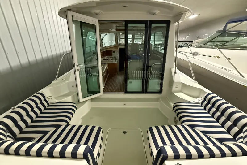 Slide: The Image of 2017 Back Cove 37 boat interior with striped seating and glass doors. - 10