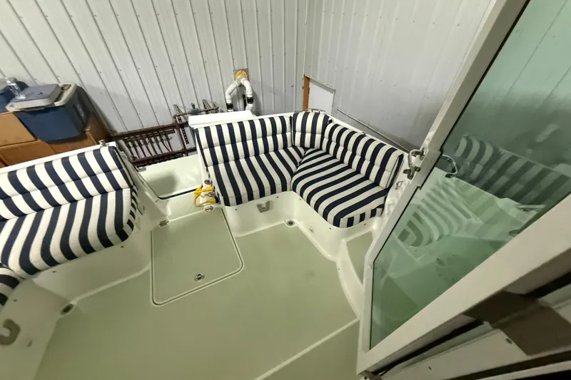 Slide: The Image of 2017 Back Cove 37 boat interior with striped seating and glass door. - 13