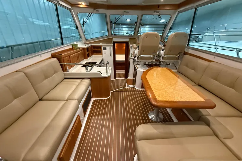 Slide: The Image of 2017 Back Cove 37 yacht interior with elegant seating, wooden table, and modern helm. - 15