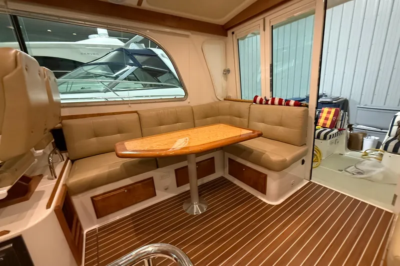 Slide: The Image of Interior of a 2017 Back Cove 37 yacht with cushioned seating and wooden table. - 18