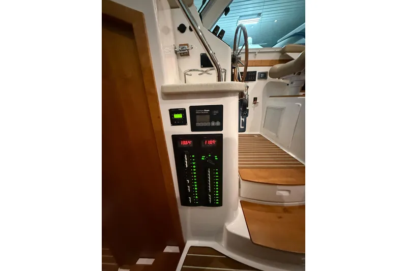 Slide: The Image of 2017 Back Cove 37 yacht interior with control panel and wooden steps. - 28